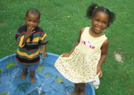 little girl and little boy standing in portable pool