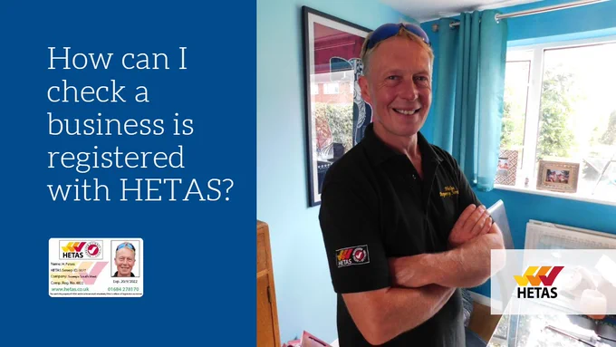 A person stood in a house wearing a work shirt with the HETAS registered installer logo with a HETAS ID, details in post
