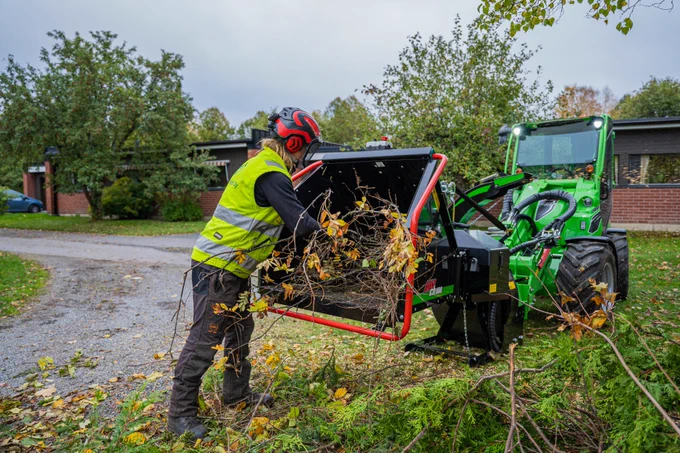 #woodchipper #loader #tractor #greenmachine #helper #worksmarternotharder man feeding braches into a wood chipper attached to a avant tecno loader