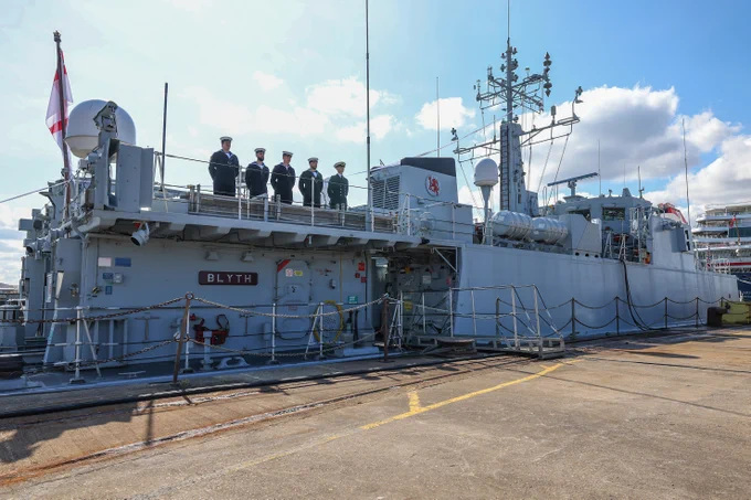 Five sailors stand on Blyth's upper deck for the ceremony