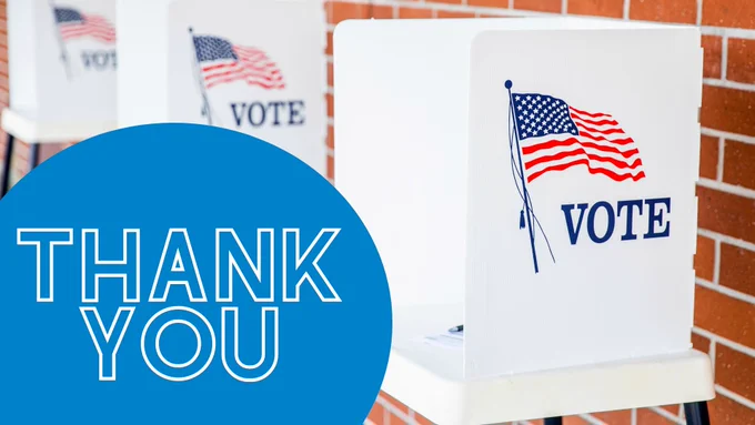 Image of polling booths lined up against a brick wall with a blue circle and the text "Thank you" in the lower left corner