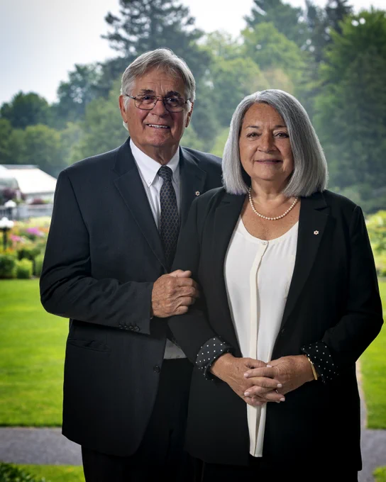 Mr. Whit Fraser and Ms. Mary Simon are posing for a photo on the grounds of Rideau Hall.