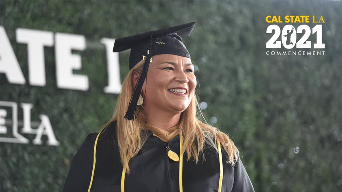 Graduate smiling in cap and gown. Top right corner Cal State LA 2021 Commencement mark
