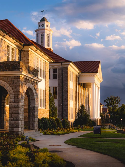 A profile view of Wilson Hall during golden hour under dramatic clouds.