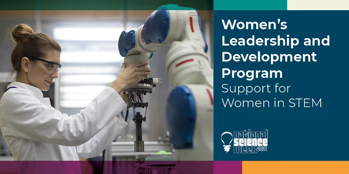 Women's Leadership and Development Program Support for Women in STEM. Pictured Women in a laboratory wearing a white lab coat and clear protective eye wear moving a white and blue robotic arm.