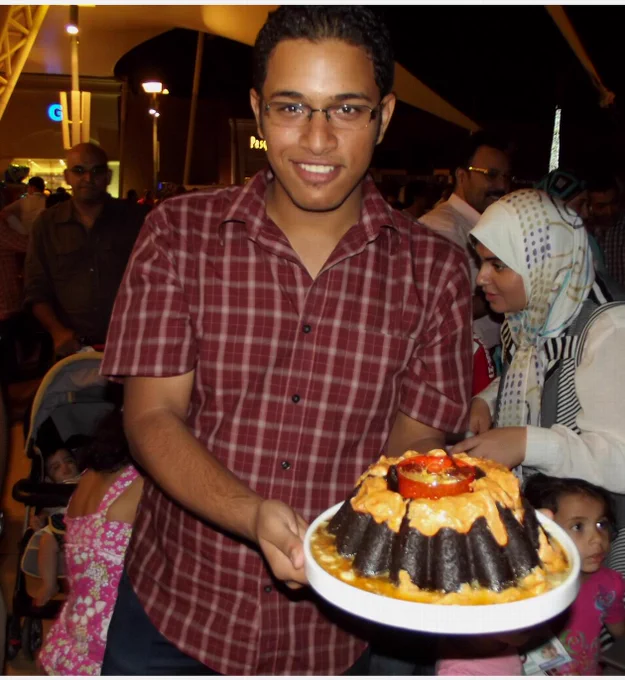 This is a photo of me in one of my very first science festivals in Egypt where I was explaining volcanos to kids using a cake. 