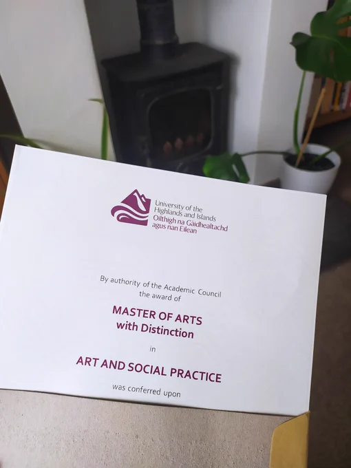A certificate that reads 'Master of Arts with Distinction in Art and Social Practice'