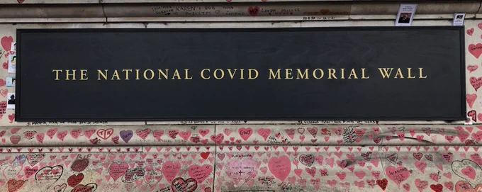 Wall covered in hearts. Plaque reads: The National Covid Memorial Wall.