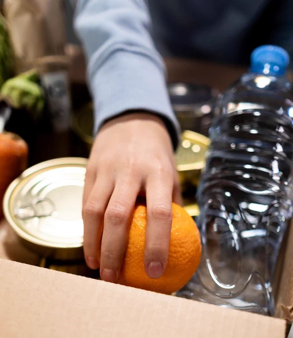 person reaching for an orange