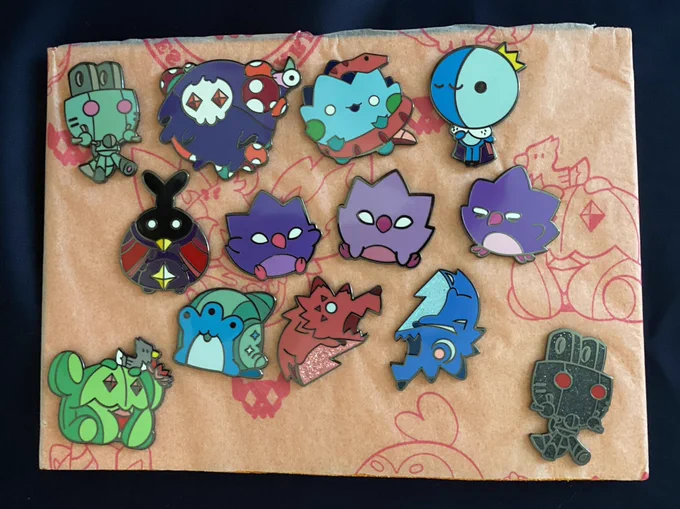 Bestiary Larry series 3 pins pinned to a tissue paper and craft foam backer