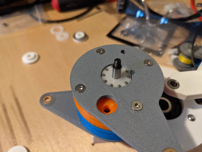 an exposed view of the laser cut thrust bearing retainer ring that holds the bearing balls inside this five bar linkage.