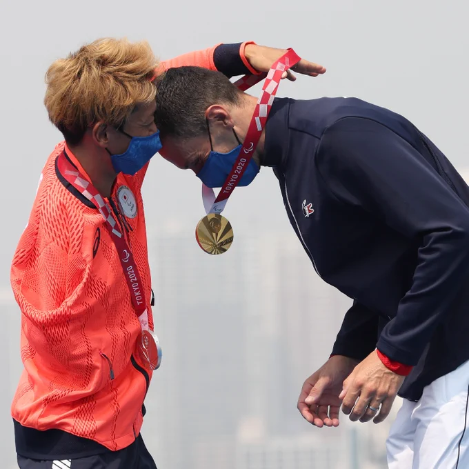  Silver medalist Hideki Uda of Team Japan gives gold medalist Alexis Hanquinquant of Team France his medal during the men's PTS4 Triathlon medal ceremony on day 4 of the Tokyo 2020 Paralympic Games