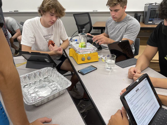 Students melting candy on a hot plate and measuring the temperature
