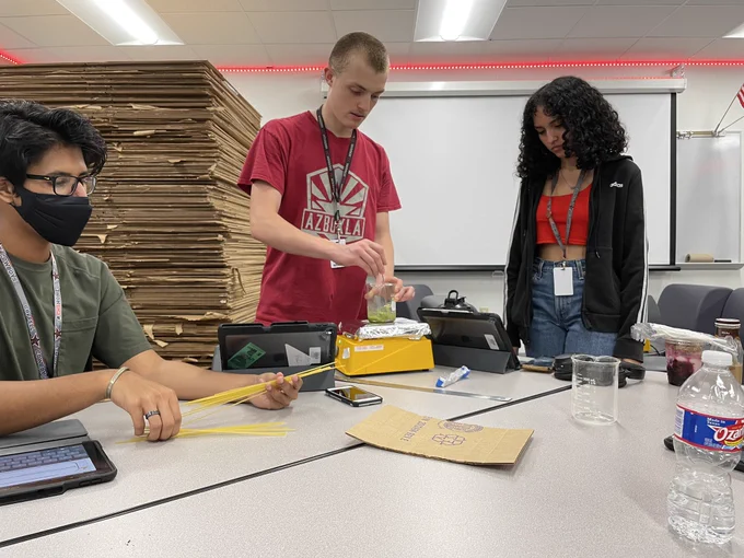 Students melting candy on a hot plate and measuring the temperature