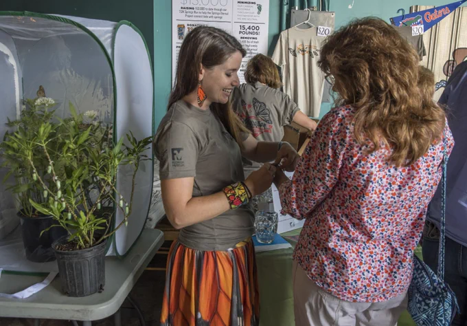 two people at an event talk over caterpillars