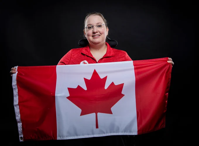 An athlete holding the Canadian Flag.