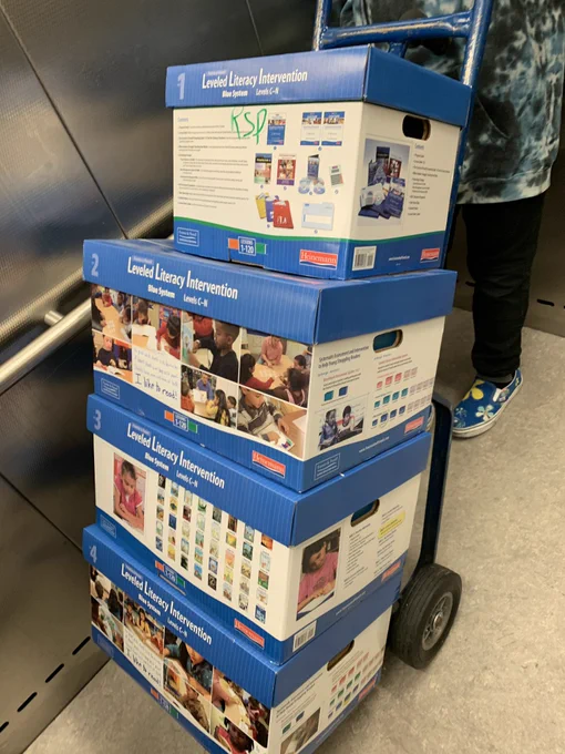 4 blue LLI kits on a cart in an elevator.