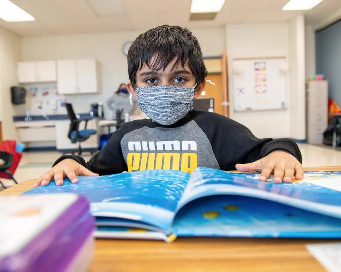 Young student reading at their desk. 