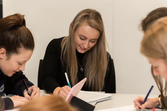 Photo: Students collaborating/writing in notebooks