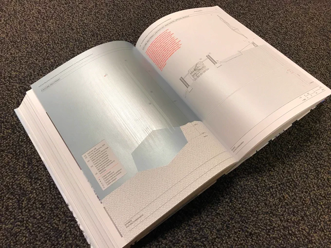 A book lying open on a table showing full-page diagrams.