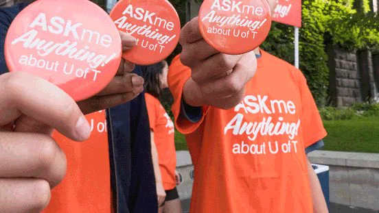 Students wearing “ASKme Anything” t-shirts and holding up buttons.