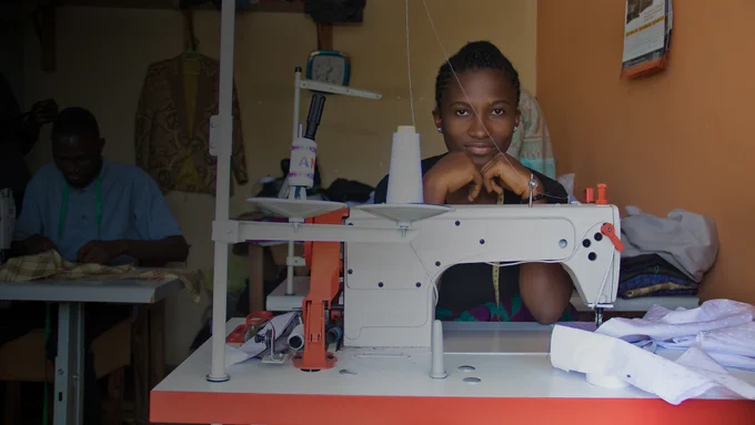 woman sitting in room behind sewing machine