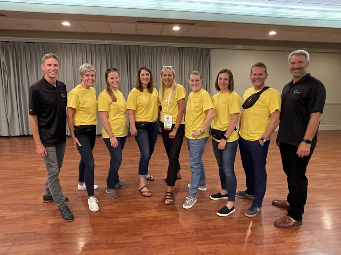 9 WIRED board members standing in line looking unified with matching shirts.  Showing excitement as a group.