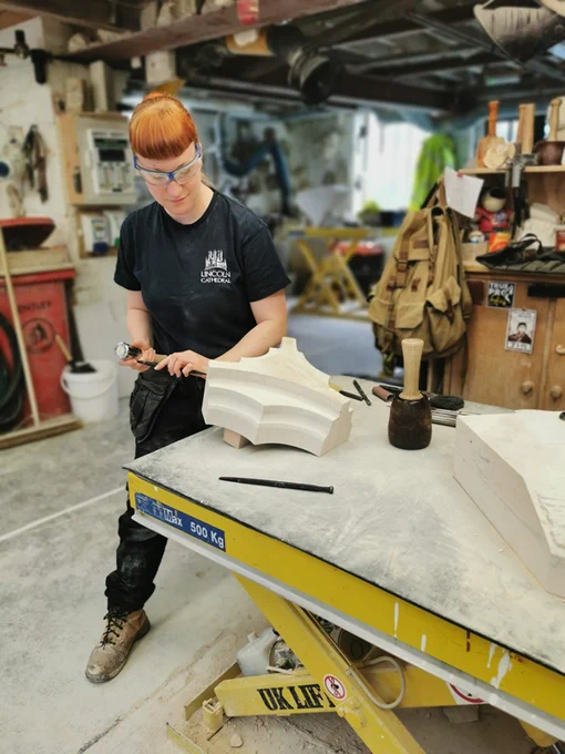 Stonemason in a workshop carving a section of stone
