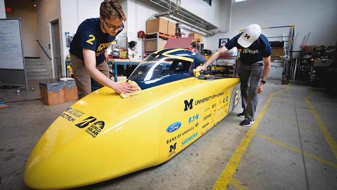 U-M engineering students clean the new solar car.