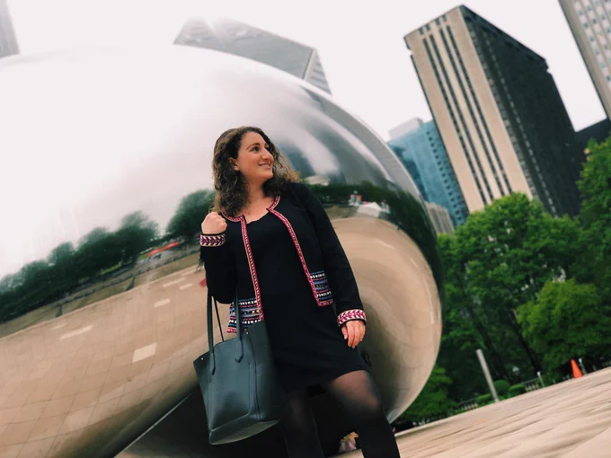 Student poses in front of Chicago's Bean structure. 
