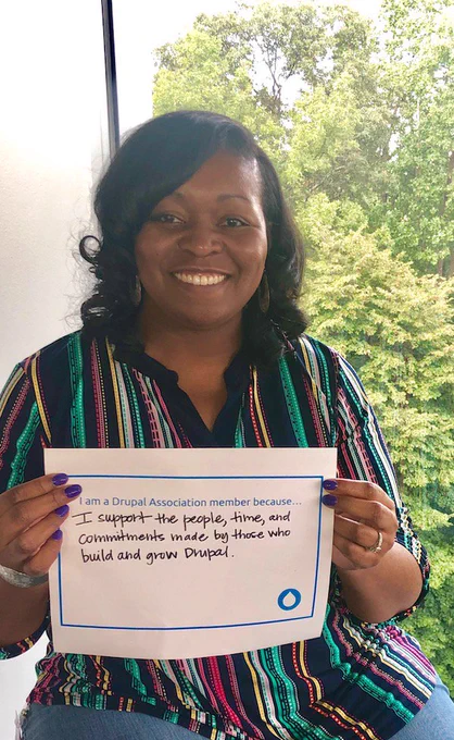 Erica holding a sign with words on why they are a member.