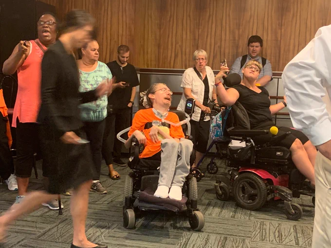 People cheer, many in wheelchairs 