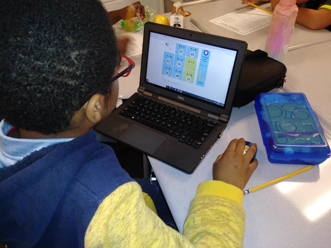 A student is playing a math game on a laptop.