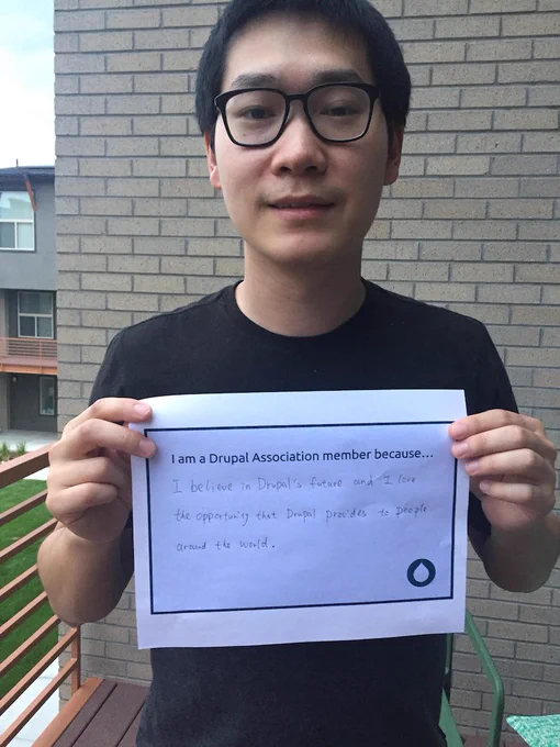 Jiang Zhan holds sign with words on why they are a member.