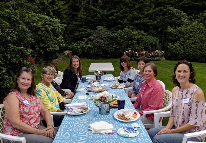 Members sitting at a picnic table. 