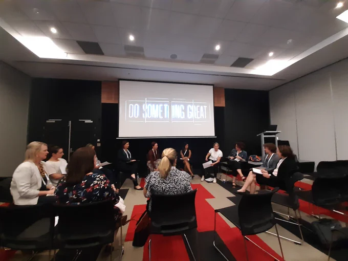 Photo of women at the Australasian Simulations Congress, sitting in a circle. Above them a screen wswittexththat says "Do something Great"