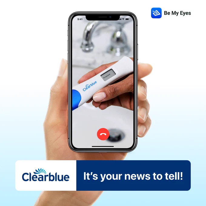 Hand holding smartphone in a Be My Eyes call. On the screen is a positive Clearblue pregnancy test. The image text reads “It’s your news to tell” together with the Clearblue and Be My Eyes logos.