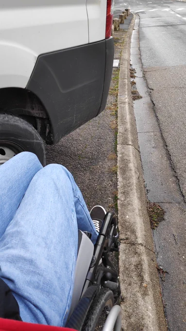 Même photo mais on voit les jambes de quelqu'un et l'avant de son fauteuil roulant