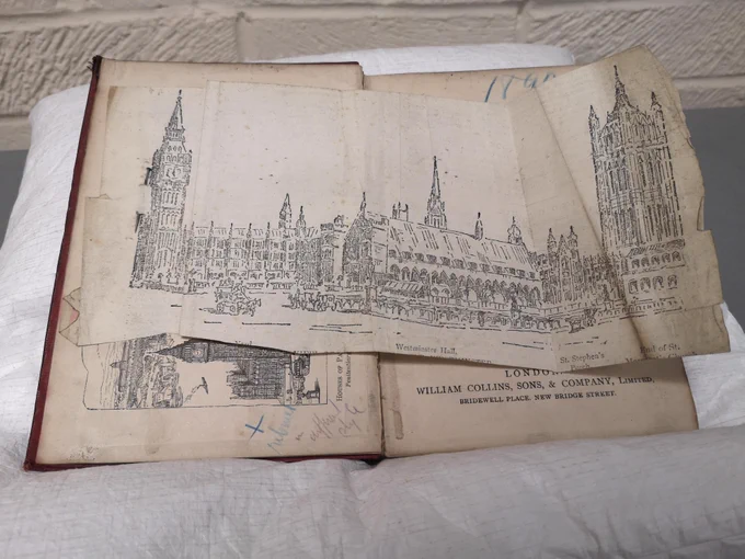 Photo of an illustration of the Houses of Parliament pinned into the front of the 'Illustrated Guide to London'.