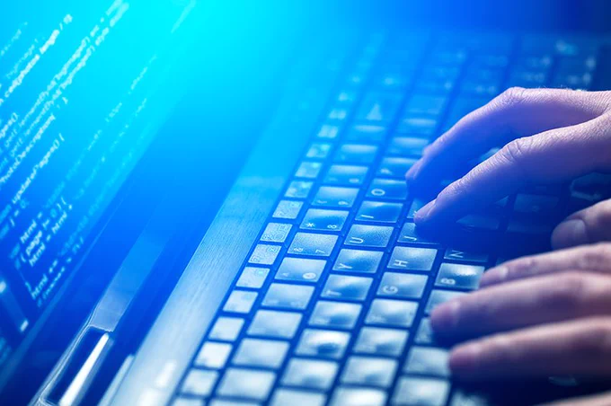 Hands typing on a computer.