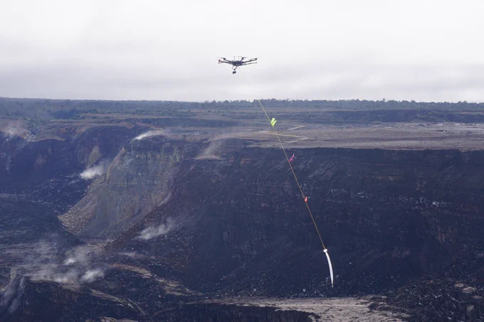 Unmanned aircraft system carrying a container for water over a volcanic crater