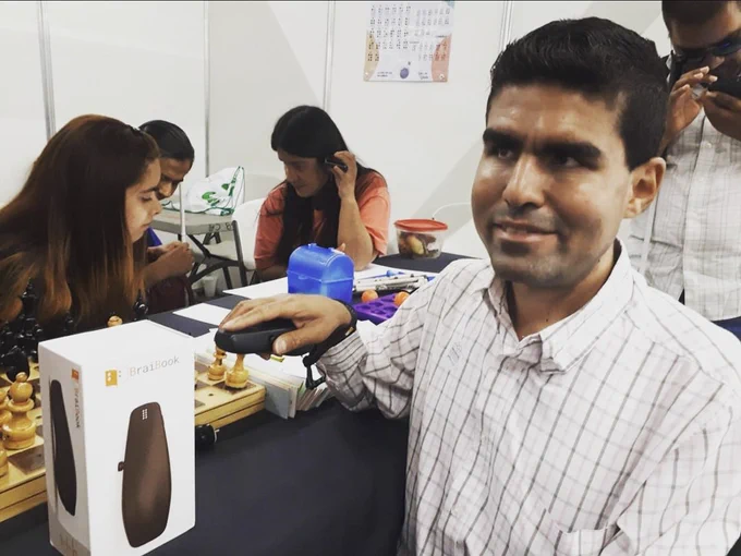 Chico en feria de tecnologías inclusivas probando BraiBook