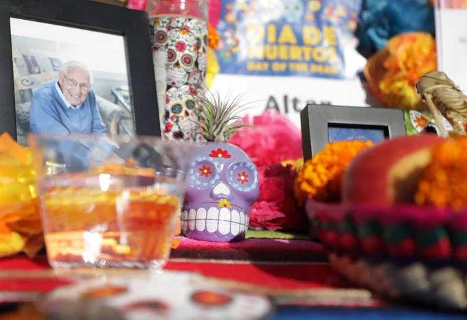 Part of an altar created for the event that includes photos of loved ones and colorful pieces of art