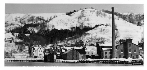 View of industrial buildings and ski hill covered in snow