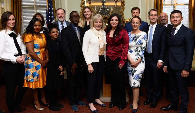 Group of people standing indoors with Director General Carol Z Perez  