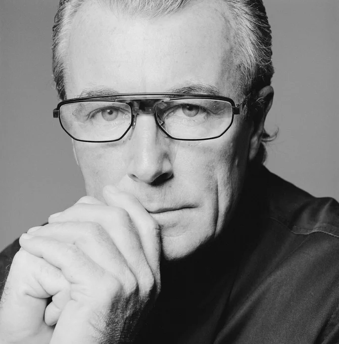 A black and white photo of a man wearing glasses 