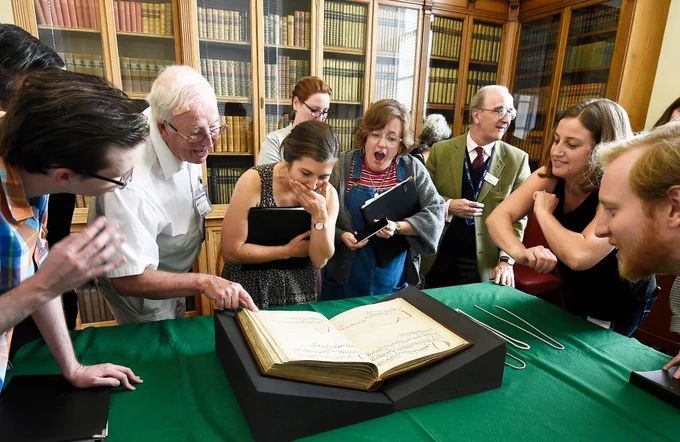 Seattle-based choral group Byrd International Singers view a medieval
music book before performing at the 2019 Edinburgh Festival Fringe.