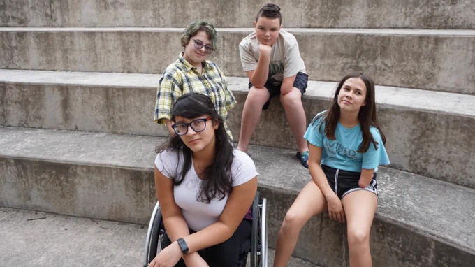 The team poses on a set of concrete stairs