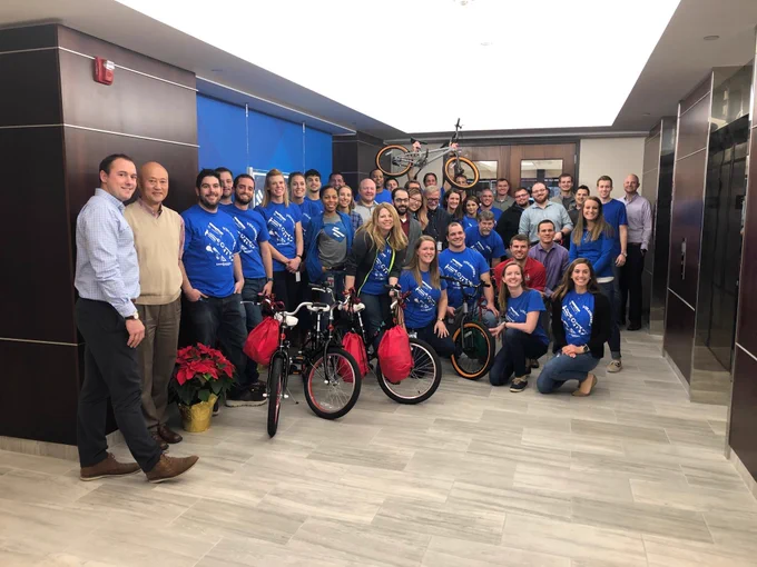 group of employees smiling with the built bikes