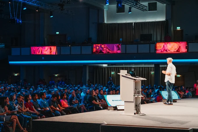 A man giving a presentation on the main state of WordCamp Europe 2019.